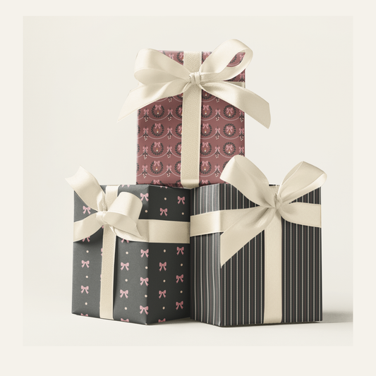 Three pink and grey Victorian gothic patterned gift boxes with white bows 