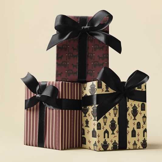 Three gift boxes with patterned wrapping paper and black ribbons on a beige background